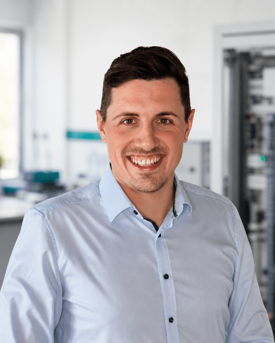 Portrait von Peter Hackenberg vor einem unscharfen technischen Hintergrund